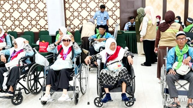 
					Jemaah haji lansia menggunakan kursi roda saat didampingi petugas PPIH Embarkasi Makassar menuju area pelayanan keberangkatan haji 2026 di Asrama Haji Sudiang Makassar, Kamis (7/5/2026) (Foto: Istimewa)