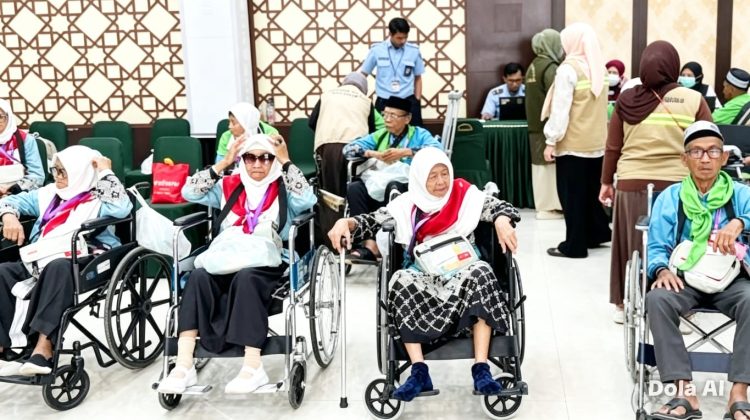 Jemaah haji lansia menggunakan kursi roda saat didampingi petugas PPIH Embarkasi Makassar menuju area pelayanan keberangkatan haji 2026 di Asrama Haji Sudiang Makassar, Kamis (7/5/2026) (Foto: Istimewa)