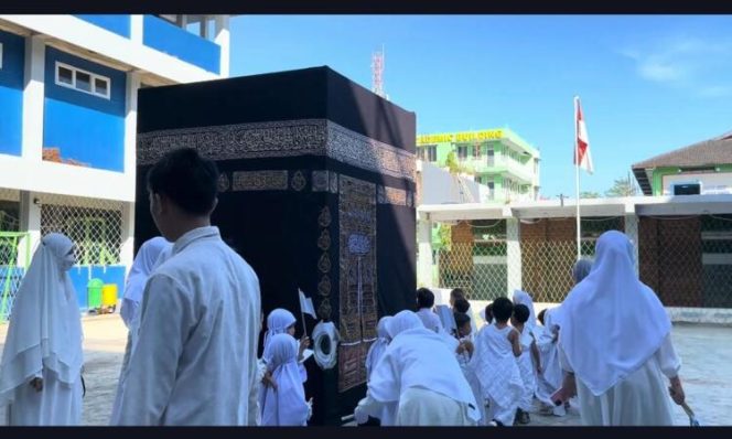 
					Siswa SIT Darul Fikri Makassar mengenakan pakaian ihram saat mengelilingi replika Ka’bah dalam kegiatan manasik haji, Makassar, Kamis (30/4/2026) (Foto: Istimewa)