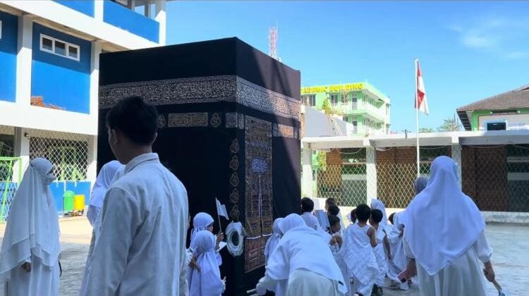 Siswa SIT Darul Fikri Makassar mengenakan pakaian ihram saat mengelilingi replika Ka’bah dalam kegiatan manasik haji, Makassar, Kamis (30/4/2026) (Foto: Istimewa)