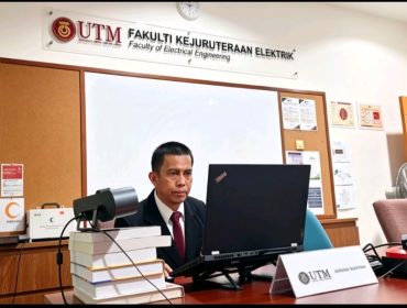 Sofyan ST MT memaparkan hasil disertasinya tentang pengaruh harmonik Solar Photovoltaic terhadap kestabilan tegangan jaringan distribusi saat menjalani ujian doktoral di hadapan tim pembimbing dan penguji di University Teknologi Malaysia (UTM). Johor Bahru, Malaysia, Jumat (12/6/2026) (Foto: Humas)