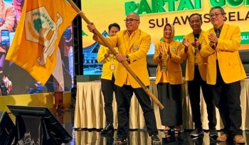 Ilham Arief Sirajuddin (IAS) mengibarkan pataka Partai Golkar usai resmi ditetapkan sebagai Ketua DPD I Partai Golkar Sulawesi Selatan periode 2026–2031 pada Musda XI Golkar Sulsel di Hotel Claro Makassar, Sabtu (18/7/2026) (Foto: Istimewa)